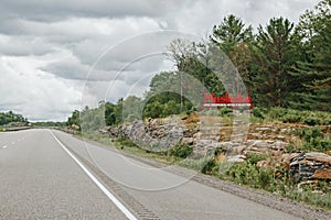 Canadian Ontario touristic destination place landmark. Red word sign Muskoka on empty road in Canada. Summer adventure trip on