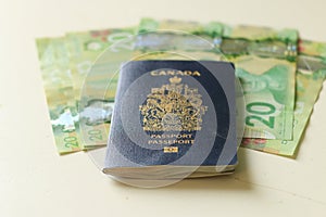 Canadian passport laying on top of twenty dollar bills. Concept of immigrating or emigrating, or travelling with a canadian
