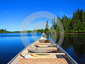 Canadian rabaska canoe resting by the calm water in beautiful  Wapizagonke lake. Mauricie National Park, Quebec Canada photo