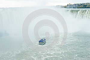 Canadian side of Niagara Falls in autumn. ship with tourists