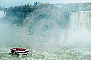 Canadian side of Niagara Falls in autumn. ship with tourists