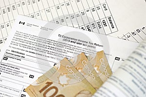 Canadian T2 tax form Corporation income tax return lies on table with canadian money bills