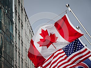 Canadian and USA flags in front of a business building in Toronto Ontario, Canada. Toronto is the biggest city of Canada