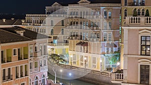 Canal aerial top view in Venice-like Qanat Quartier of the Pearl precinct of Doha night timelapse, Qatar.