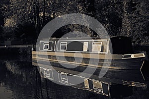 Canal barge boat moored on the Shropshire Union Canal, reflected in the water.