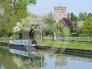 Canal barge moored by a church.