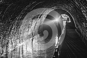 Canal boat travelling through a canal tunnel in the UK.