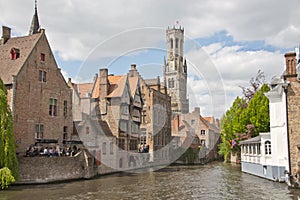 A canal in Bruges, Belgium, with the famous Belfry in the background.