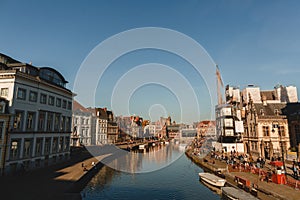 canal and buildings reflected in water at sunny day, Ghent, Belgium