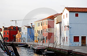 Canal and colorful houses lit by the setting sun in Burano Venice area Italy