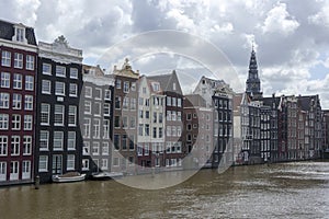 Canal houses right on the water of the Damrak in Amsterdam