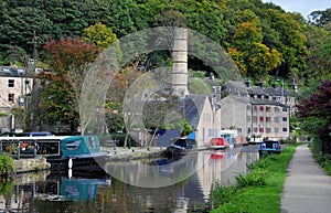 The canal and marina in hebden bridge with boats on the water, towpath and surrounding hillside trees
