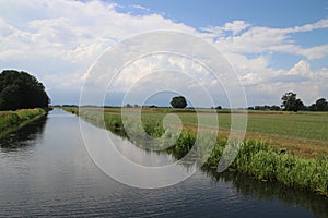 Canal Raaltewetering in Wijhe the Netherlands with a lot of cumulus stormclouds above it which reflecting