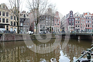 canal, river and brick buildings at singel - amsterdam - netherlands
