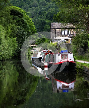 Canal Scene near Hebden Bridge Halifax showing barges and tree lined waterway.