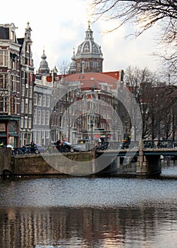 Canal and townhouses, dome of the Basilica of Saint Nicholas in the background, Amsterdam, Netherlands