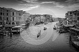 Venice canal and gondola and boats from the Rialto Bridge in black and white photo