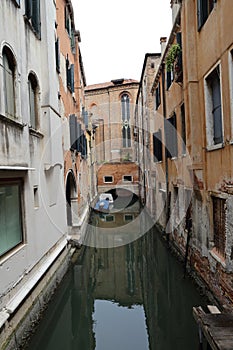 Canal in Venice with docked gondola and boats,