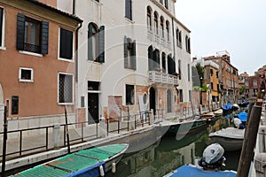 Canal in Venice with docked gondola and boats,