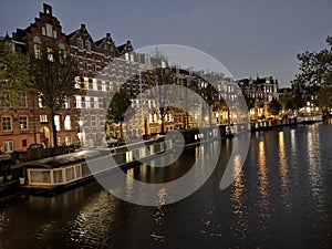 Canals, bridge, bike and houses of Amsterdam city, in Holland, Netherlands at night