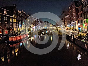 Canals and houses of Amsterdam city at night, in Holland, Netherlands