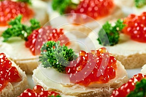 Canapees with red caviar and parsley