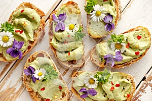 Canapes with avocado paste and edible flowers