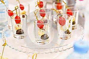 canapes with cherry tomato, mozzarella and olive in cups