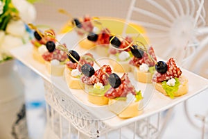 canapes with cherry tomato, sausage and olive