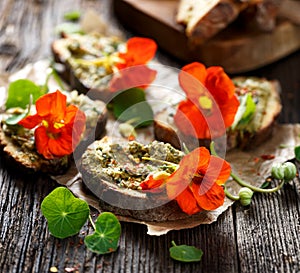 Canapes with herb pesto and edible nasturtium flowers