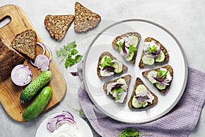 CanapÃÂ©s with toasted bread with sunflower and flax seeds, feta cheese, cucumber and onion photo