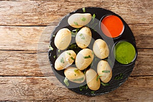 Canarian food wrinkly potatoes are boiled unpeeled potatoes served with two local sauces close-up on a slate plate. horizontal top