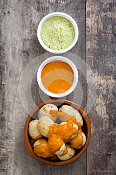 Canarian potatoes (papas arrugadas) with mojo sauce on wooden table photo