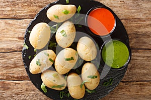 Canarian Wrinkly Potatoes Papas Arrugadas with a mojo rojo and mojo verde sauces close up in the plate. Horizontal top view