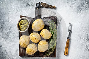 Canary Islands dish Papas Arrugadas, wrinkly potatoes with Mojo verde green sauce. White background. Top view