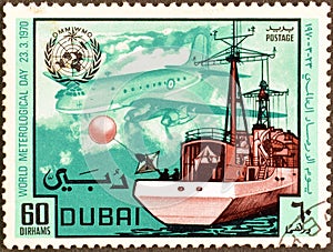 Cancelled postage stamp printed by Dubai, that shows Ocean Weather Ship Launching Radio Sonde, and Hastings Plane, World Day of Me