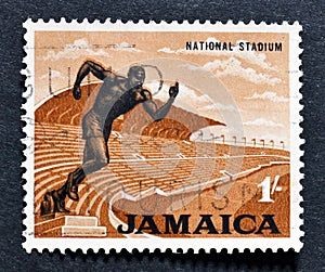 Cancelled postage stamp printed by Jamaica, that shows National Stadium and statue of runner