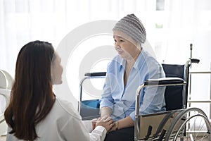 Cancer patient woman wearing head scarf after chemotherapy consulting and visiting doctor in hospital