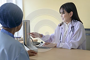 Cancer patient woman wearing head scarf after chemotherapy consulting and visiting doctor in hospital