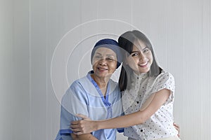 Cancer patient woman wearing head scarf and her supportive daughter in hospital, health and insurance concept