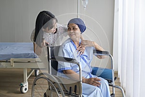 Cancer patient woman wearing head scarf and her supportive daughter in hospital, health and insurance concept