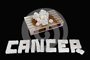 Word cancer written with white refined sugar cubes