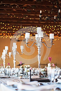 Candelabra with candles on decorated wedding reception tables photo