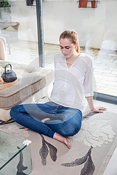 Candid beautiful young woman leaning back for morning yoga practice