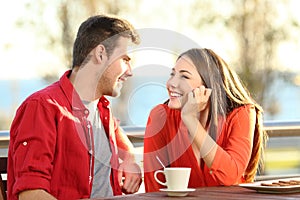 Candid couple in love flirting in a terrace