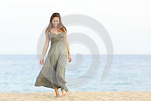 Candid dreamer girl walking on the sand of the beach photo