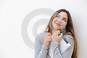 Candid innocent teenager girl cuddling a tablet and looking above photo