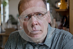 Candid mature man in eyewear looking seriously to camera with real emotions of attention or fear