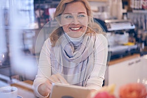 Candid mature woman looking sidewards from behind window