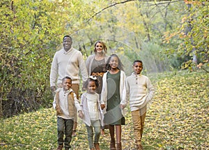 Candid Mixed Race family portrait outdoors with autumn colors